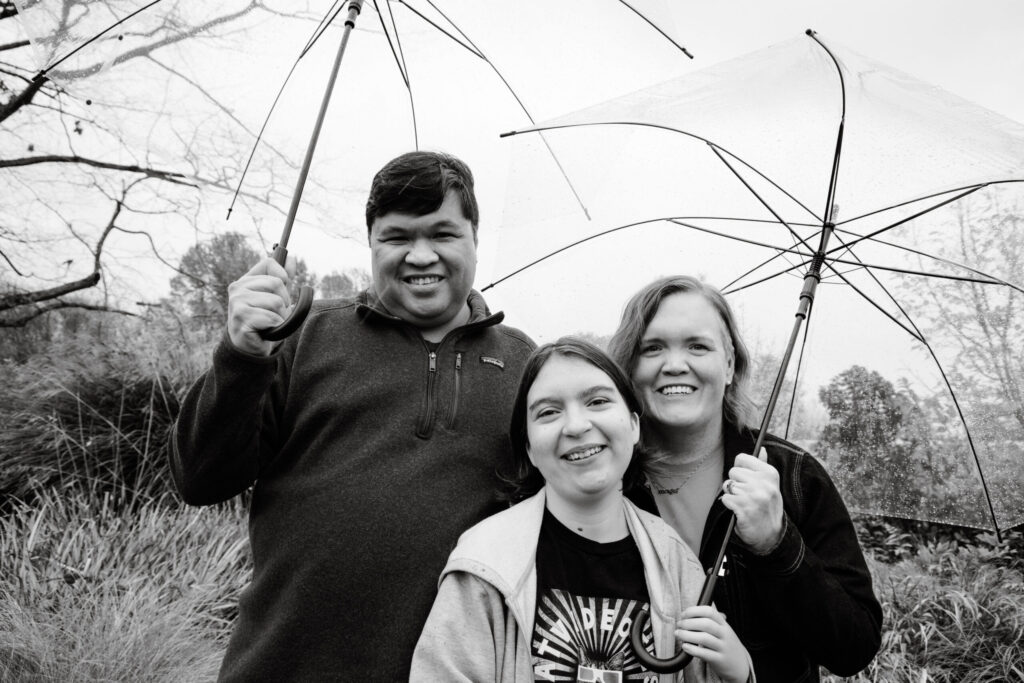Carrie with her family under clear umbrellas